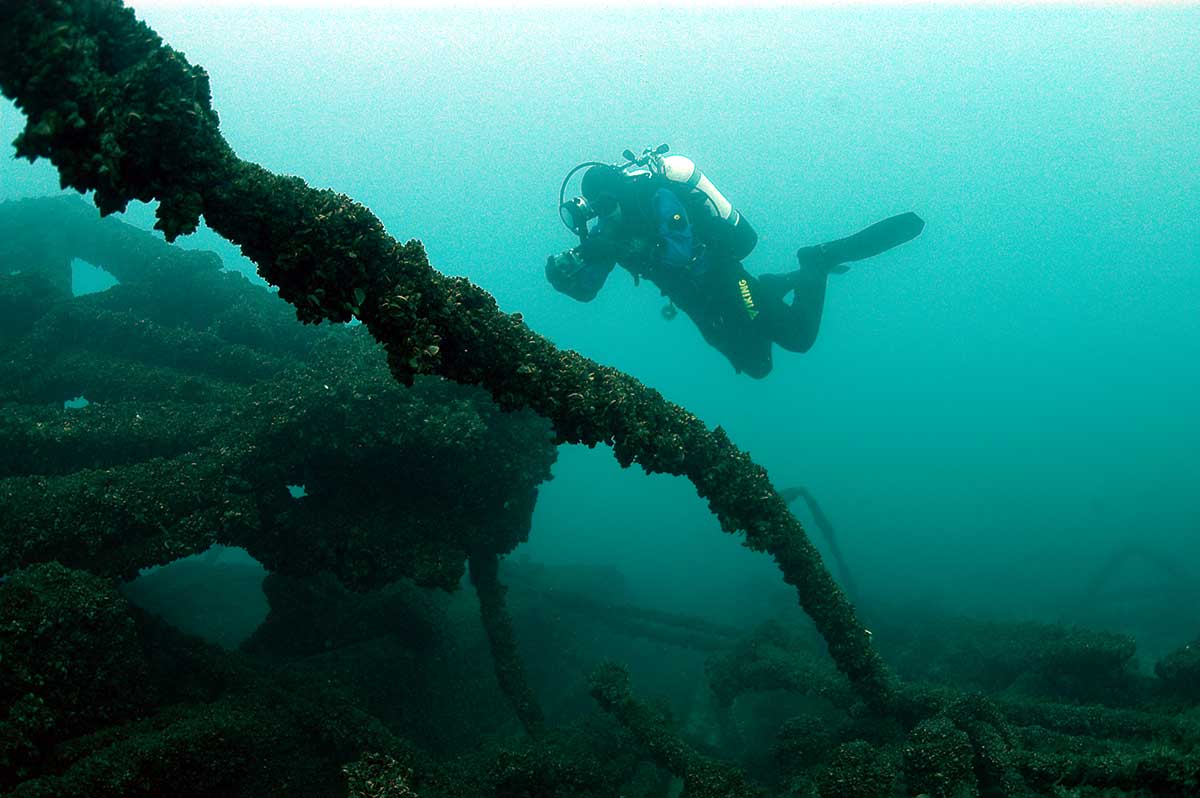 An archaeologist photographs the remains of the paddle-wheel. Photo by WHS, Maritime Preservation and Archaeology Program, via Wisconsin Shipwrecks 
